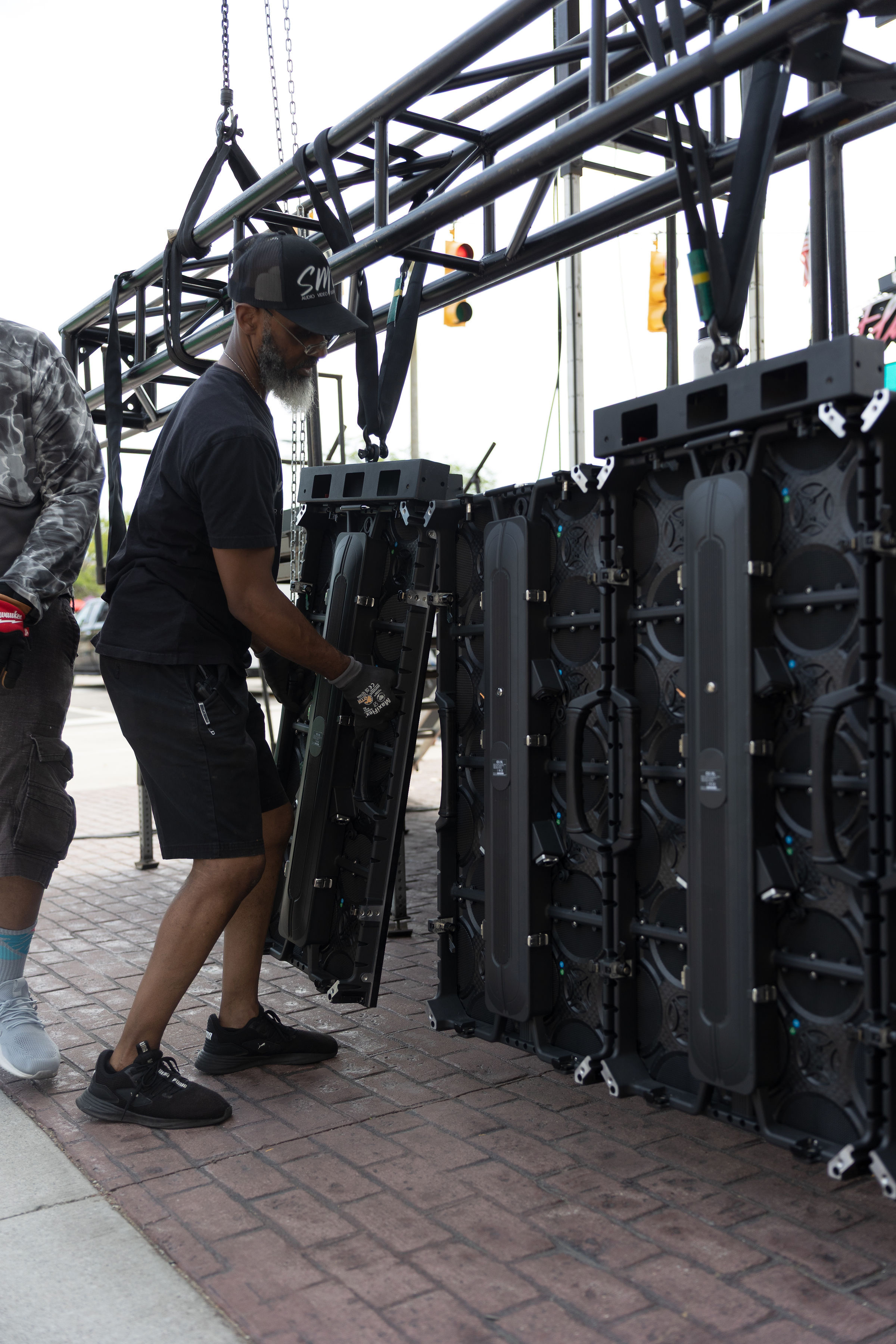 Crew member working on a line array cabinet on the ground