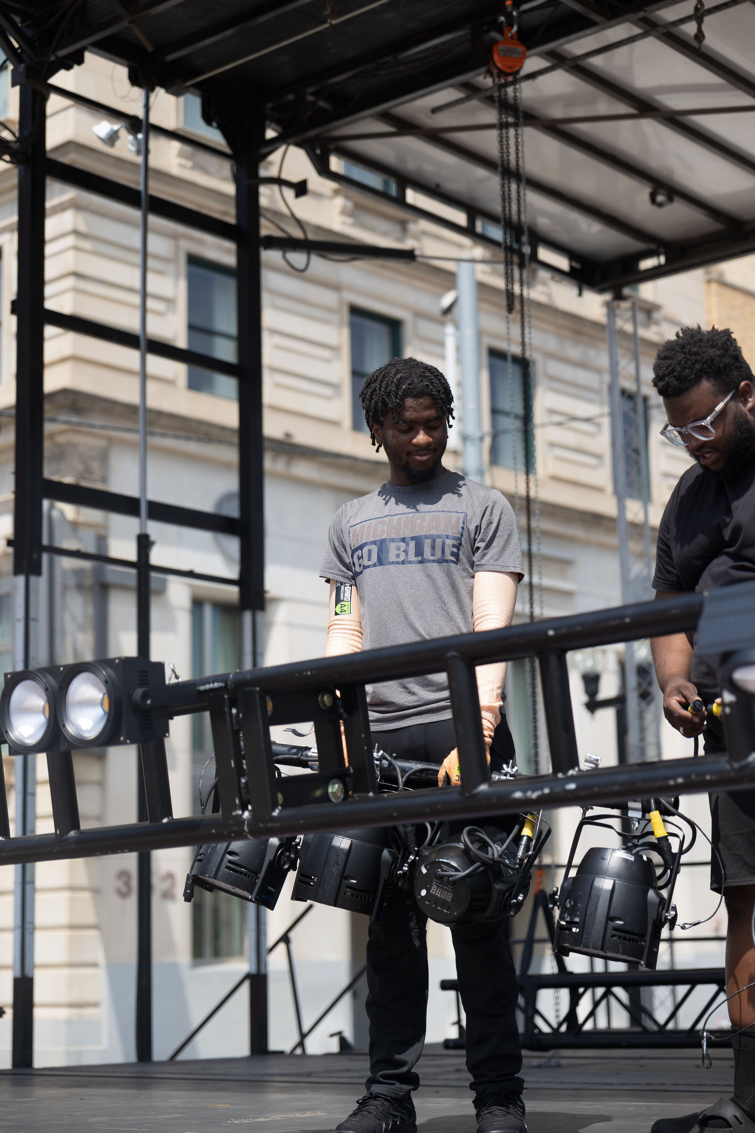 Crew members holding stage light fixtures