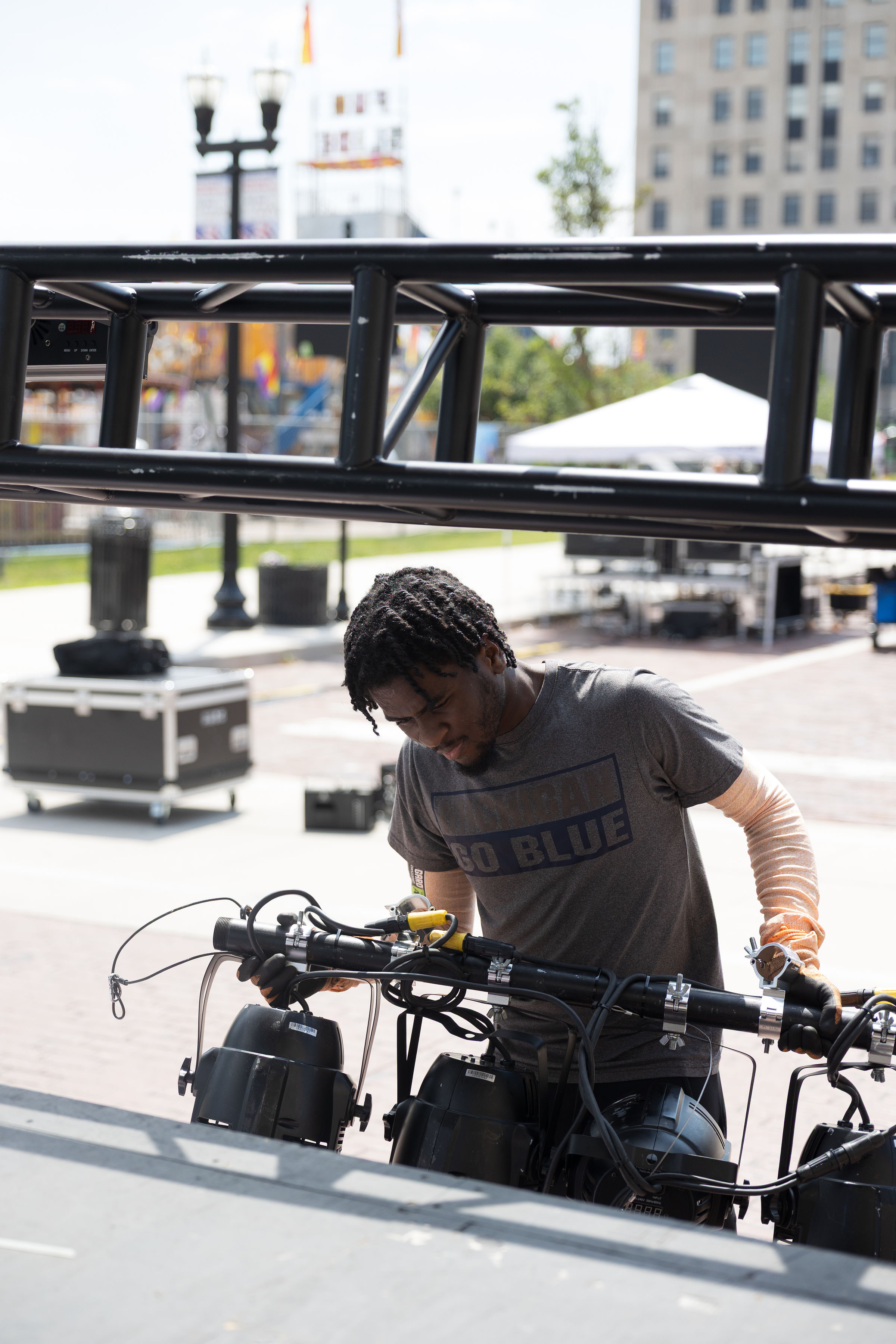 Crew member working on lighting fixtures under the truss
